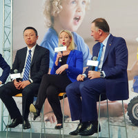 Dr Julie Bhosale holding a microphone, in discussion with John Key